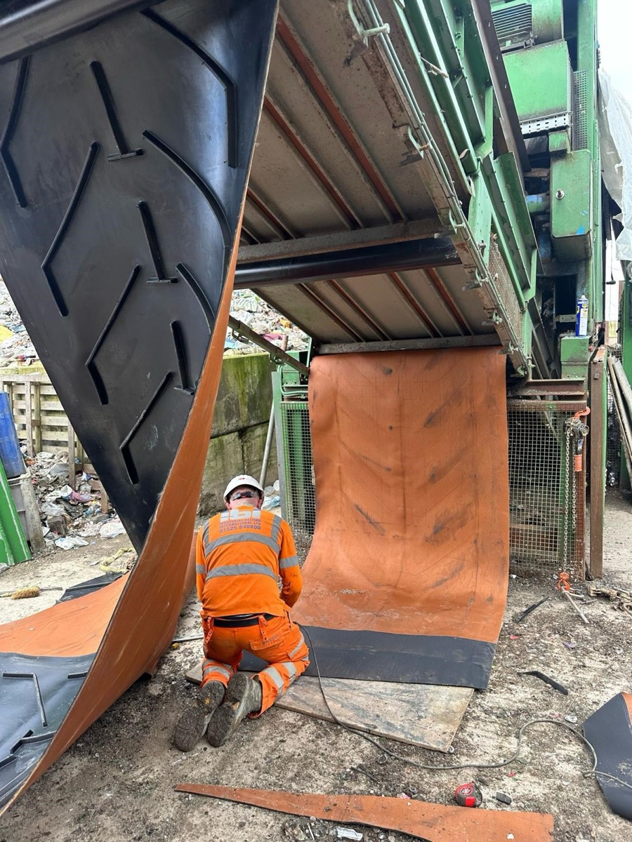 IBI engineer fitting a chevron-cleated belt on an incline conveyor